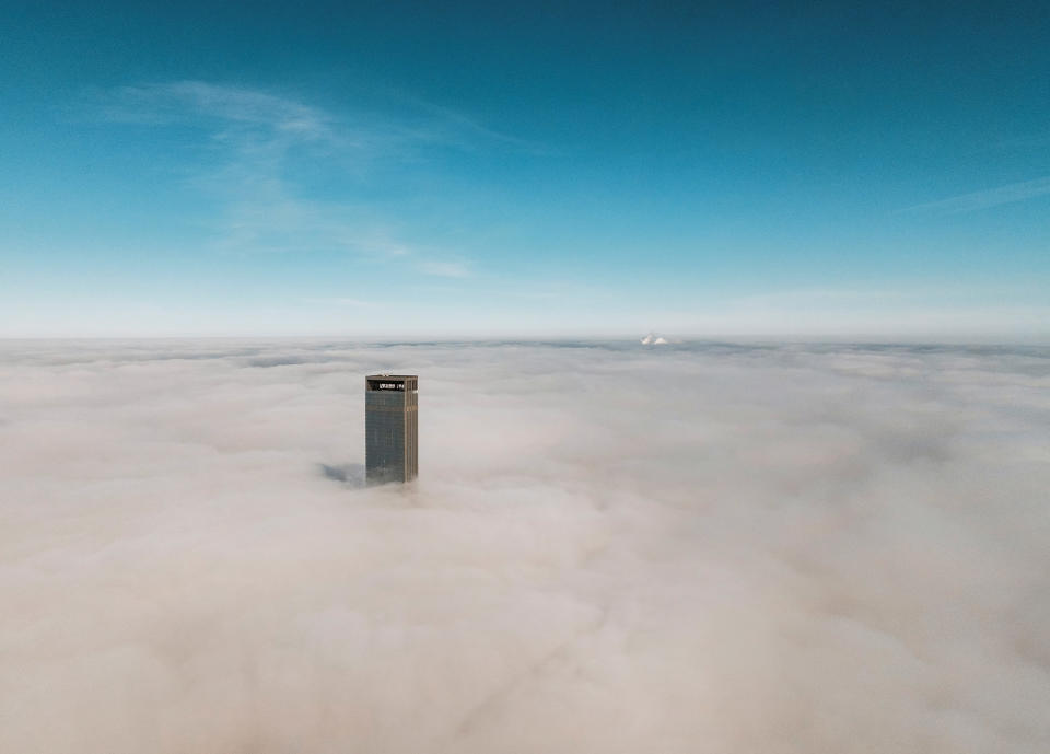 A tower of Abu Dhabi Plaza sticks out of a blanket of thick fog in Astana, Kazakhstan, March 24, 2023. 