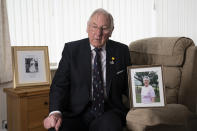 Gordon Bonner holds a photograph of his wife Muriel who, in April 2020 died of COVID-19, at his home in Leeds, England Saturday Jan. 23, 2021. Bonner, 86, is just one of many hundreds of thousands of Britons toiling with grief because of the pandemic. With more than 2 million dead worldwide, people the world over are mourning loved ones, but the U.K.'s toll weighs particularly heavily: It is the smallest nation to pass the 100,000 mark. ( AP Photo/Jon Super)