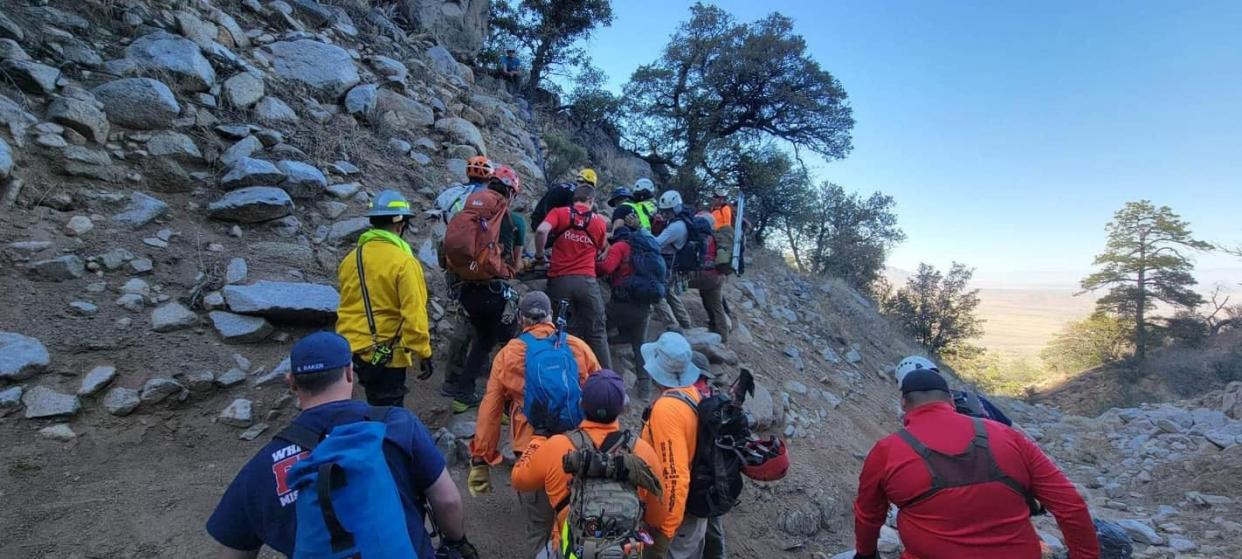 A collection of search and rescue workers labor to remove an injured woman for the Organ Mountains on April 1, 2023.