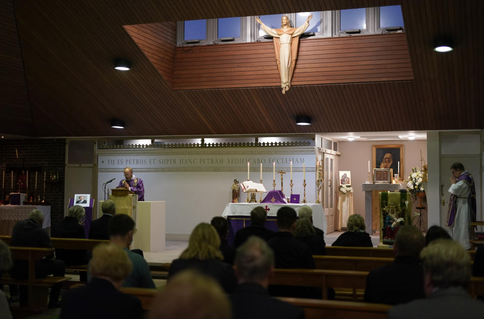 People attend a vigil to murdered British Conservative lawmaker David Amess in St Peters Catholic Church in Leigh-on-Sea, Essex, England, Friday, Oct. 15, 2021. Amess died after being stabbed earlier Friday during a meeting with constituents at another nearby church in eastern England. Police gave no immediate details on the motive for the killing of 69-year-old Conservative lawmaker Amess and did not identify the suspect, who was being held on suspicion of murder. (AP Photo/Alberto Pezzali)