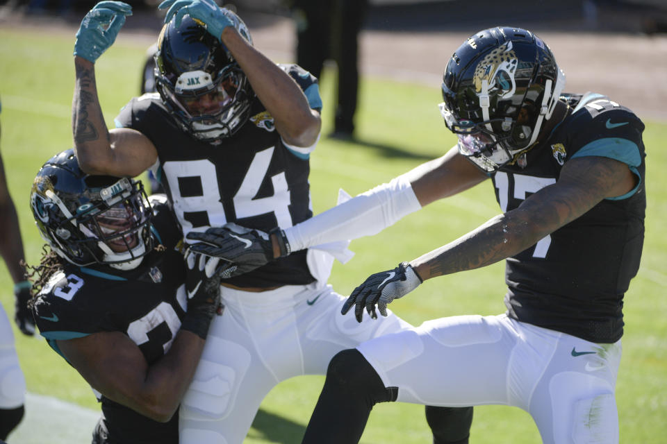 Jacksonville Jaguars wide receiver DJ Chark Jr., right, celebrates his touchdown reception against the Chicago Bears with teammates wide receiver Keelan Cole Sr. (84) and running back Dare Ogunbowale (33) during the first half of an NFL football game, Sunday, Dec. 27, 2020, in Jacksonville, Fla. (AP Photo/Phelan M. Ebenhack)