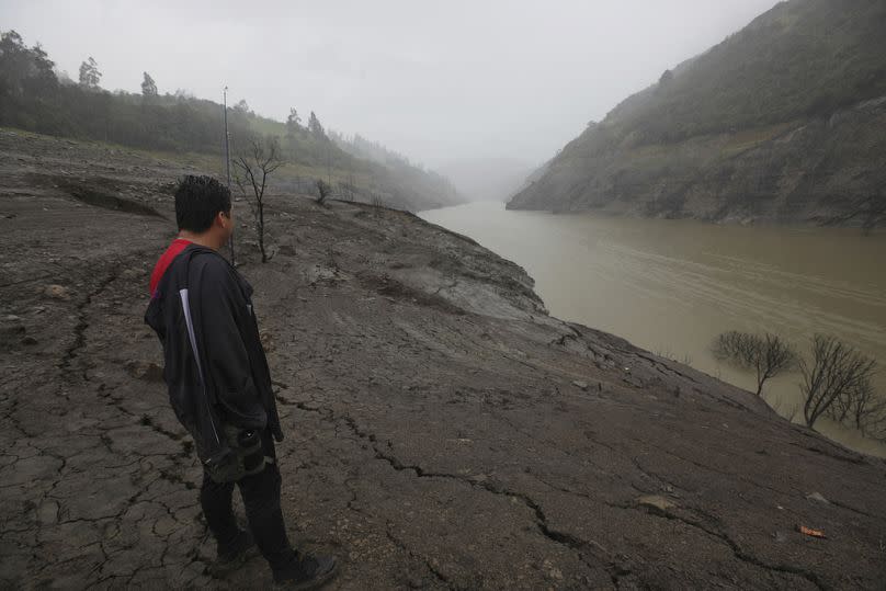 A man stands on the exposed banks of the Mazar reservoir, in the Azuay province of Ecuador.