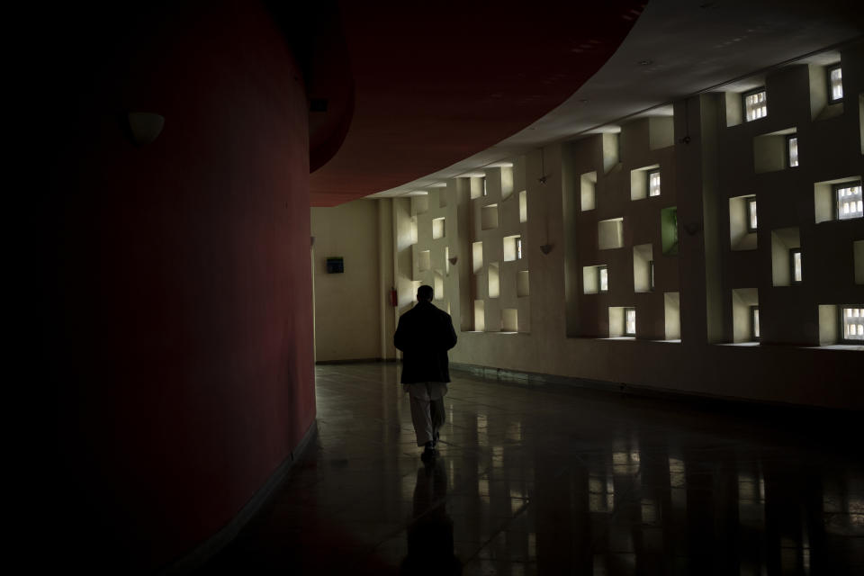 A staff member walks in the hallways of the Ariana Cinema on Thursday, Nov. 4, 2021. The cinema's staff still show up at work every day hoping they will eventually get paid, despite the Taliban's orders to stop operating. (AP Photo/Bram Janssen)