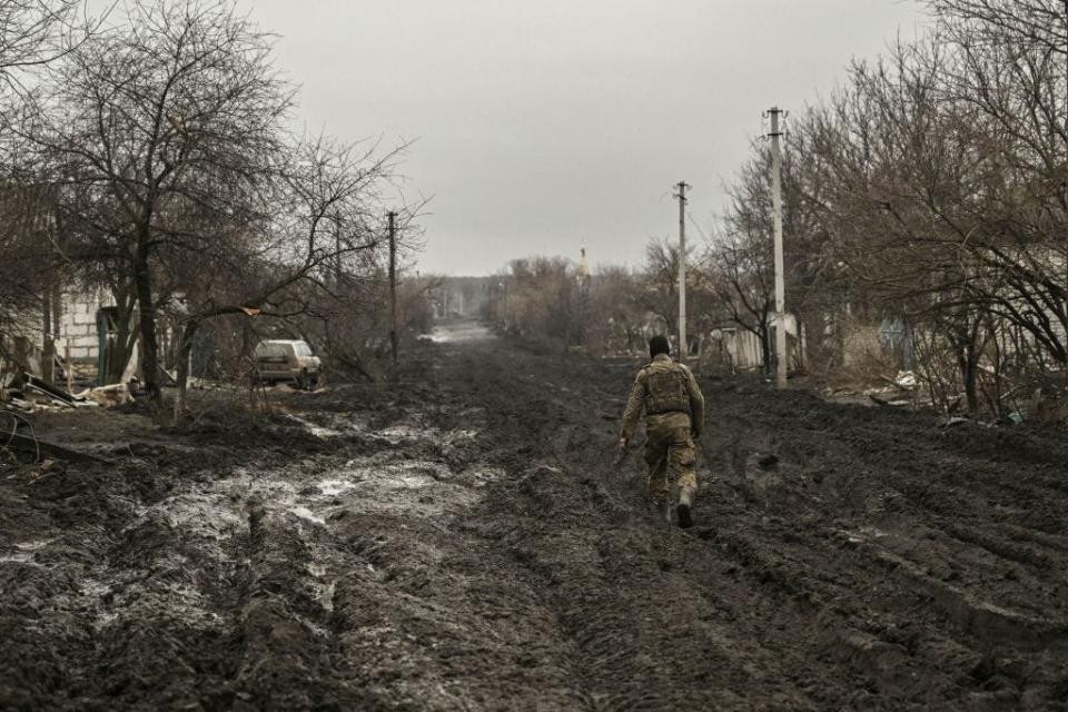 A Ukrainian serviceman walks on a muddy road near Bakhmut in the Donbas region, on March 9, 2023.