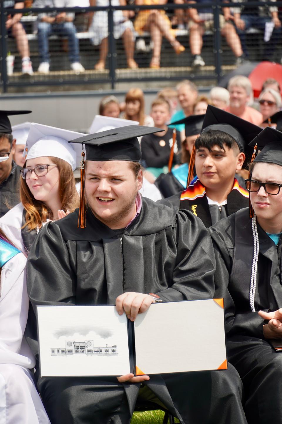 A graduate shows his empty diploma portfolio. Diplomas are given to seniors after all course work is verified.