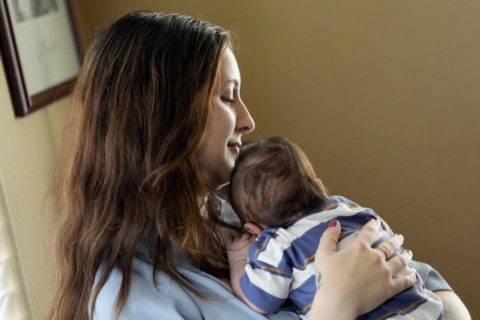 Kirsten Terrill, 25, poses for a photograph with her one-month-old son, Mateo, at her home, Wednesday, June 5, 2024, in Chandler, Ariz. Terrill, an academic advisor at a community college in Arizona, leveraged the Pregnant Workers Fairness Act to secure leave to recover from the birth of her Mateo in May. Without the new law, Kirsten wouldn't have been guaranteed time off because she hadn't been with her employer long enough to qualify for the Family and Medical Leave Act. (AP Photo/Matt York)