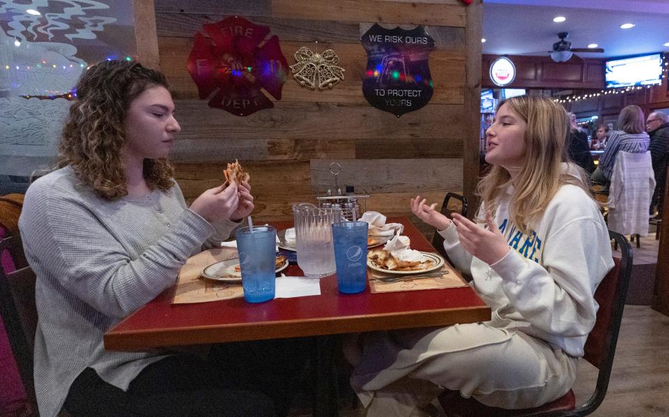 Cousins Kaitlin Hintelmann of Tinton Falls and Katherine Murphy of Red Bank dig into their XXL pies in an attempt to win the prized T-shirts at Carmen's Pizza in Neptune City.