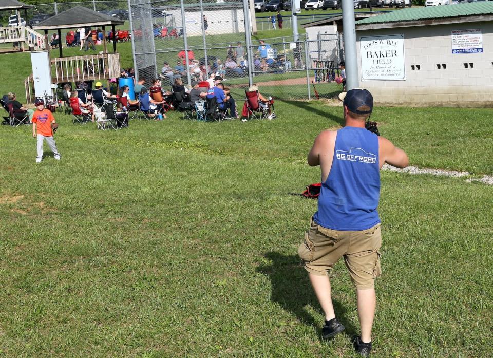 Keenan Gates helps his son Gunner Gates warm up before his Tee Ball game for the 7- to 9-year-olds on May 13, 2024.