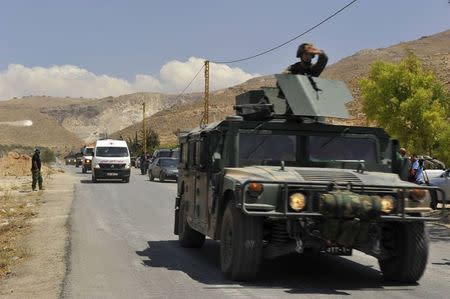 Lebanese army soldiers escort ambulances believed to be carrying casualties as they return from the Sunni Muslim border town of Arsal, in eastern Bekaa Valley August 5, 2014. REUTERS/Hassan Abdallah