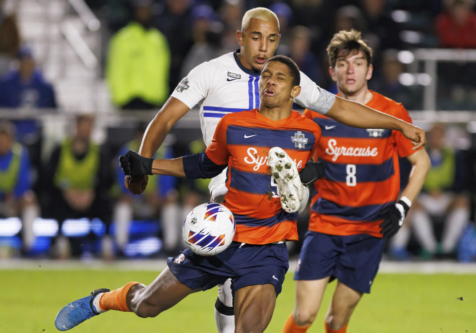 Creighton's Charles Auguste, rear left, and Syracuse's Amferny Sinclair (5) compete for the ball during the second half of an NCAA men's soccer tournament semifinal in Cary, N.C., Friday, Dec. 9, 2022. (AP Photo/Ben McKeown)