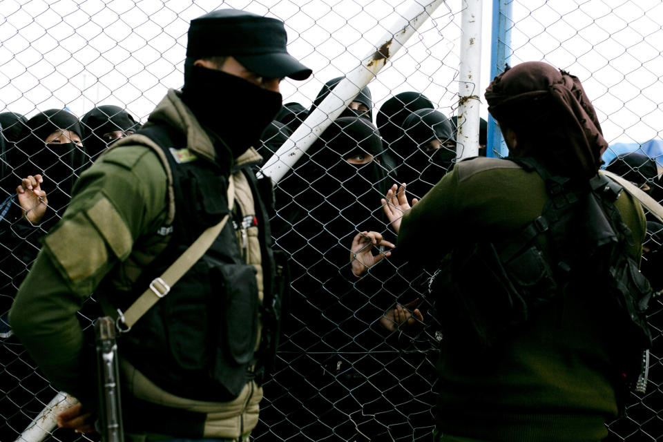 FILE - In this March 31, 2019 file, photo, women speak to guards at the gate that closes off the section for foreign families who lived in the Islamic State's so-called caliphate, at Al-Hol camp in Hasakeh province, Syria. The IS could get a new injection of life if conflict erupts between the Kurds and Turkey in northeast Syria as the U.S. pulls its troops back from the area. The White House has said Turkey will take over responsibility for the thousands of IS fighters captured during the long campaign that defeated the militants in Syria. But it’s not clear how that could happen. (AP Photo/Maya Alleruzzo, File)