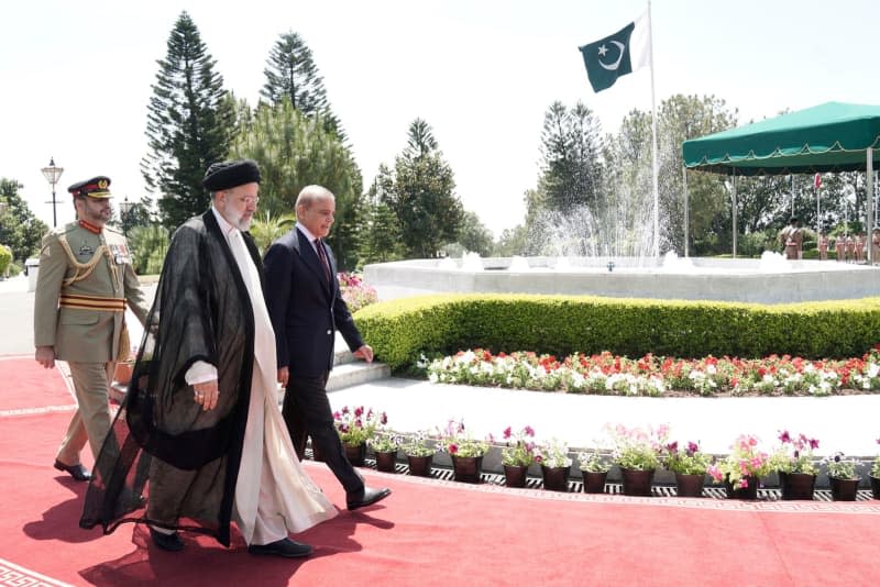 Prime Minister of Pakistan Shehbaz Sharif (R) receives Iranian President Ebrahim Raisi (C) ahead of their meeting. -/Iranian Presidency/dpa