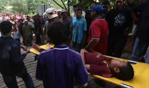 Emergency teams carry out an injured boy at the site of a landslide that hit an orphanage in Hulu Langat, Selangor. A landslide caused by heavy rains hit an orphanage in Malaysia on Saturday, killing at least 10 children and two caretakers, the official Bernama news agency said