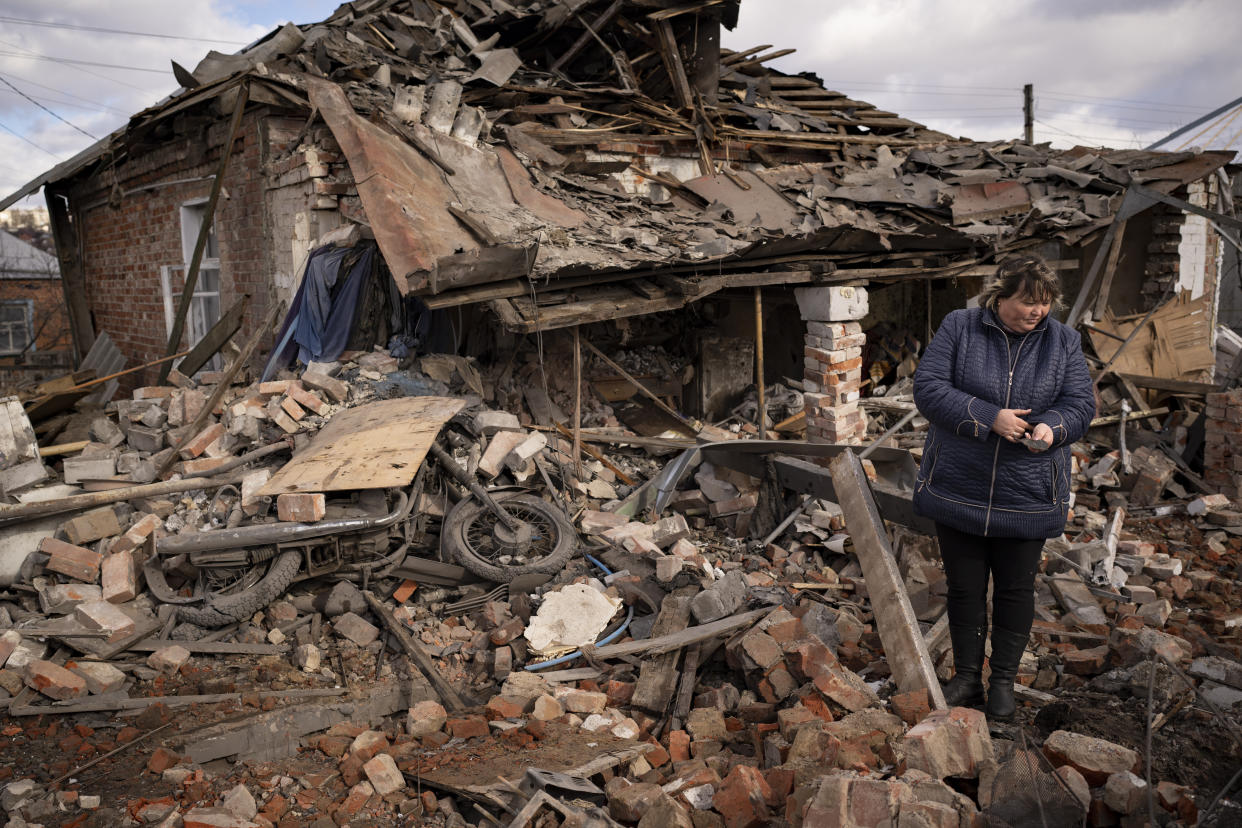 FILE - A woman holds a piece of shrapnel standing in the rubble of a house where Ukrainian servicemen were sheltering which destroyed by a Russian S-300 rocket strike, in Kupiansk, Ukraine, Monday, Feb. 20, 2023. Grueling artillery battles have stepped up in recent weeks in the vicinity of Kupiansk, a strategic town on the eastern edge of Kharkiv province by the banks of the Oskil River as Russian attacks intensifying in a push to capture the entire industrial heartland known as the Donbas, which includes the Donetsk and the Luhansk provinces. (AP Photo/Vadim Ghirda, File)