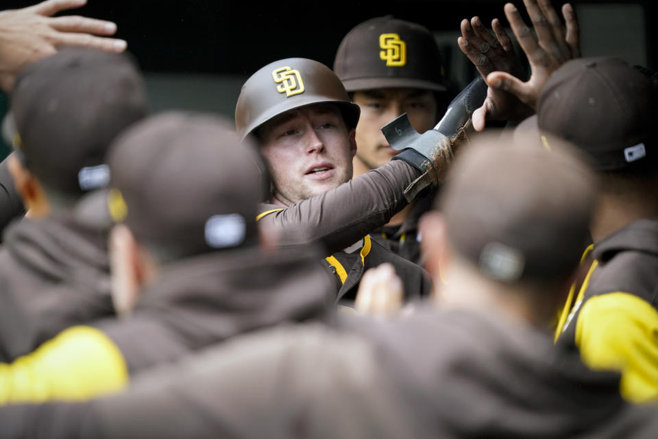 San Diego Padres' Jake Cronenworth, center, celebrates with teammates after scoring on an RBI single hit by Eric Hosmer during the first inning of a baseball game against the Cincinnati Reds, Thursday, April 28, 2022, in Cincinnati. (AP Photo/Jeff Dean)