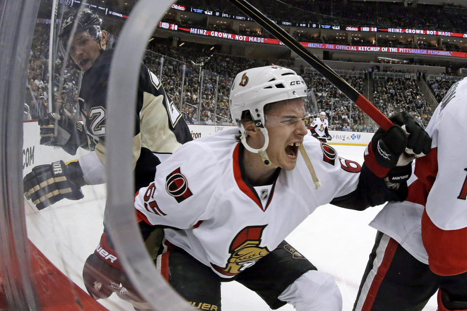 FILE - In this Feb. 13, 2013, file photo, Ottawa Senators defenseman Erik Karlsson (65) grimaces as he falls to the ice after colliding with Pittsburgh Penguins left wing Matt Cooke, left, during the second period of an NHL hockey game in Pittsburgh. Recent NHL history is full of serious but thankfully not fatal injuries from skate cuts, from Erik Karlsson's torn Achilles tendon a decade ago to Evander Kane's sliced wrist last year. (AP Photo/Gene J. Puskar, File)