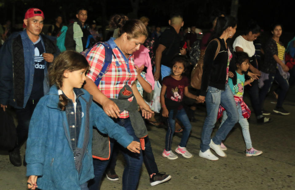 Migrants walk along a highway in hopes of reaching the distant United States, in San Pedro Sula, Honduras, before sunrise Wednesday, Jan. 15, 2020. Hundreds of Honduran migrants started walking and hitching rides Wednesday from the city of San Pedro Sula, in a bid to form the kind of migrant caravan that reached the U.S. border in 2018. (AP Photo/Delmer Martinez)