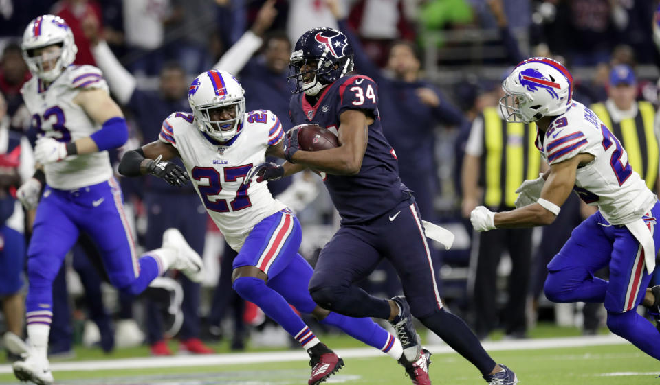 Houston Texans running back Taiwan Jones (34) catches a pass and runs for a first down as Buffalo Bills' Tre'Davious White (27) and Kevin Johnson (29) defend during overtime of an NFL wild-card playoff football game Saturday, Jan. 4, 2020, in Houston. (AP Photo/Michael Wyke)