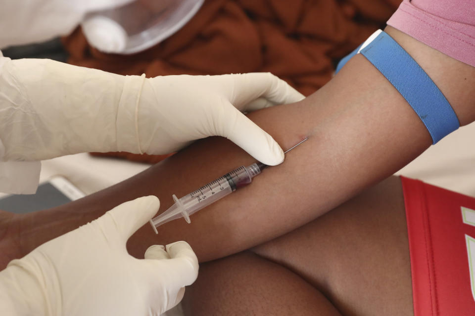 A health worker takes a blood sample from a COVID-19 patient at the Dr. Suyoto General Hospital in Jakarta, Indonesia, on July 29, 2021. As coronavirus cases skyrocket and deaths climb in Indonesia, health care workers are being depleted as the virus spares nobody. (AP Photo/Tatan Syuflana)