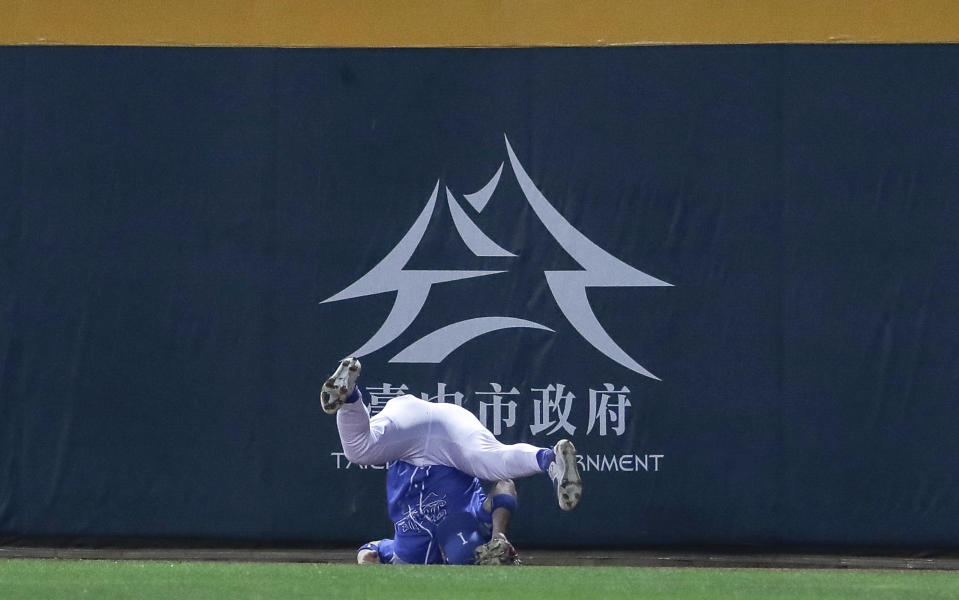 Italy's Dominic Fletcher misses the ball and falls upside down during the third inning of a Pool A game against the Netherlands at the World Baseball Classic (WBC) at Taichung Intercontinental Baseball Stadium in Taichung, Taiwan, Sunday, March 12, 2023. (AP Photo/I-Hwa Cheng)