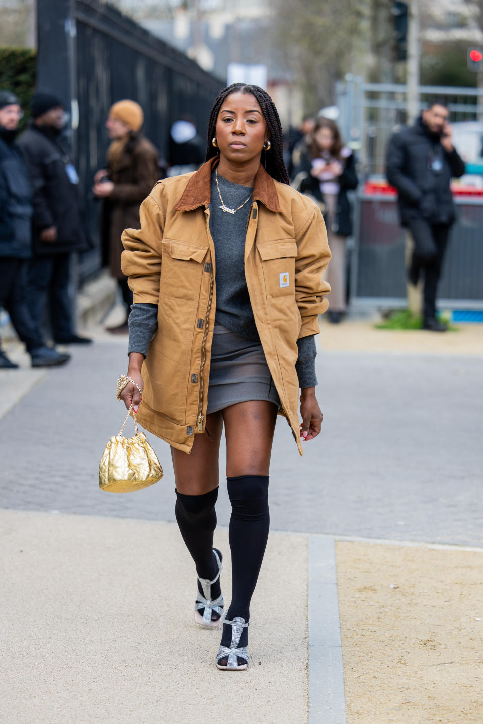 A guest at fashion week wearing a carhartt jcaket and knee socks