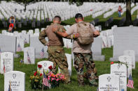 <p>U.S. Army soldiers Rick Kolberg, left, and Jesus Gallegos comfort each other as they visit the graves of Raymond Jones and Peter Enos on Memorial Day at Arlington National Cemetery in Arlington, Va., on May 30, 2016. (Lucas Jackson/Reuters) </p>