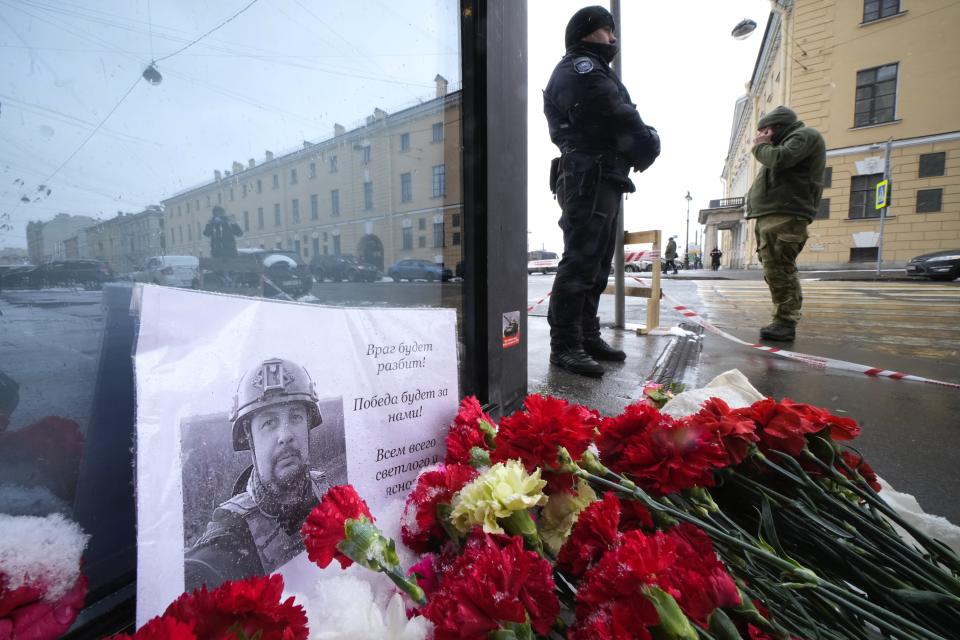 Flowers and a poster with a photo of blogger Vladlen Tatarsky placed near the site of an explosion at the "Street Bar" cafe in St. Petersburg, Russia, Monday, April 3, 2023. An explosion tore through a cafe in Russia’s second-largest city, killing a well-known military blogger and strident supporter of the war in Ukraine. Some reports said a bomb was embedded in a bust of the blogger that was given to him as a gift. Russian officials said Vladlen Tatarsky was killed Sunday as he led a discussion at the cafe in the historic heart of St. Petersburg. (AP Photo/Dmitri Lovetsky)