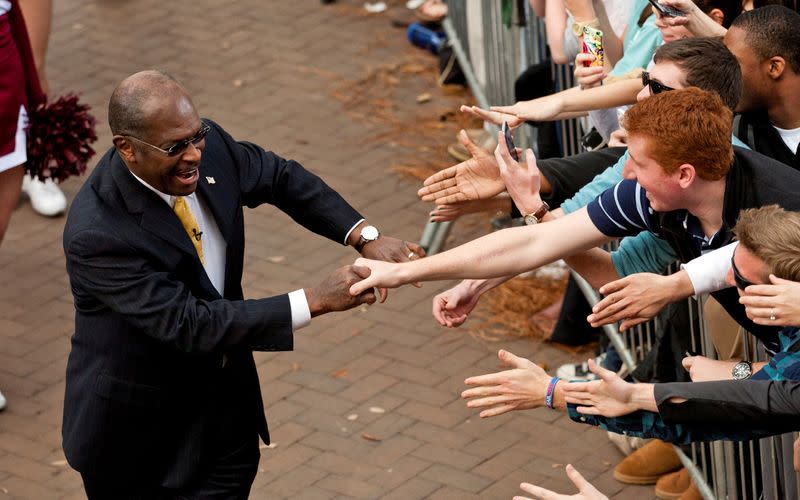 FILE PHOTO: Herman Cain shakes hands as he leaves a South Carolina primary rally at the College of Charleston