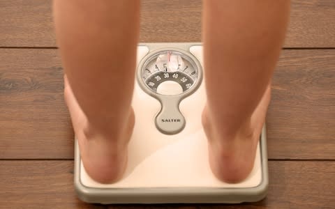 Child using a set of weighing scales. - Credit: Chris Radburn/PA&nbsp;