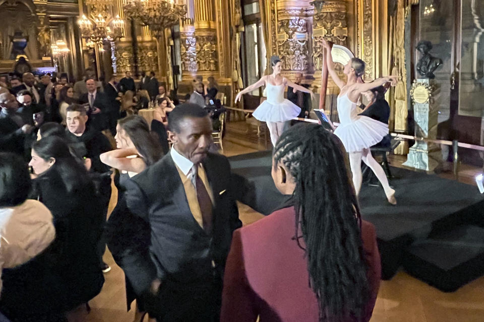 Detroit Pistons coach Dwayne Casey, center left, talks while ballet performers entertain during a reception at the Paris Opera house Tuesday night Jan. 17, 2023, in Paris France. The Detroit Pistons play the Chicago Bulls in Paris on Thursday. (AP Photo/Tim Reynolds)