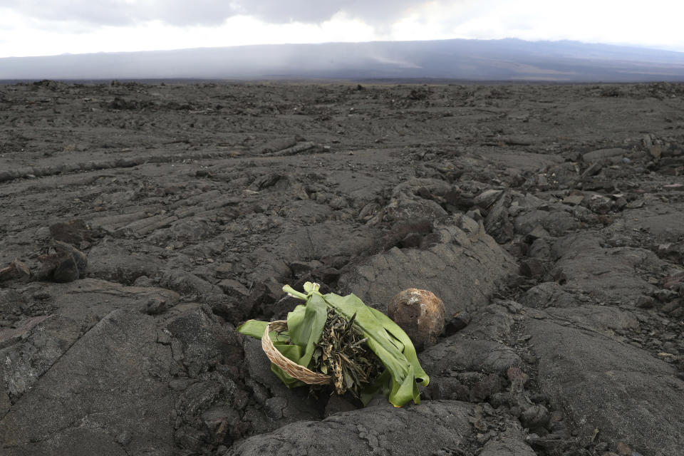 A Native Hawaiian offering is left on an old lava field in front of the erupting Mauna Loa, Tuesday, Nov. 29, 2022, near Hilo, Hawaii. (AP Photo/Marco Garcia)