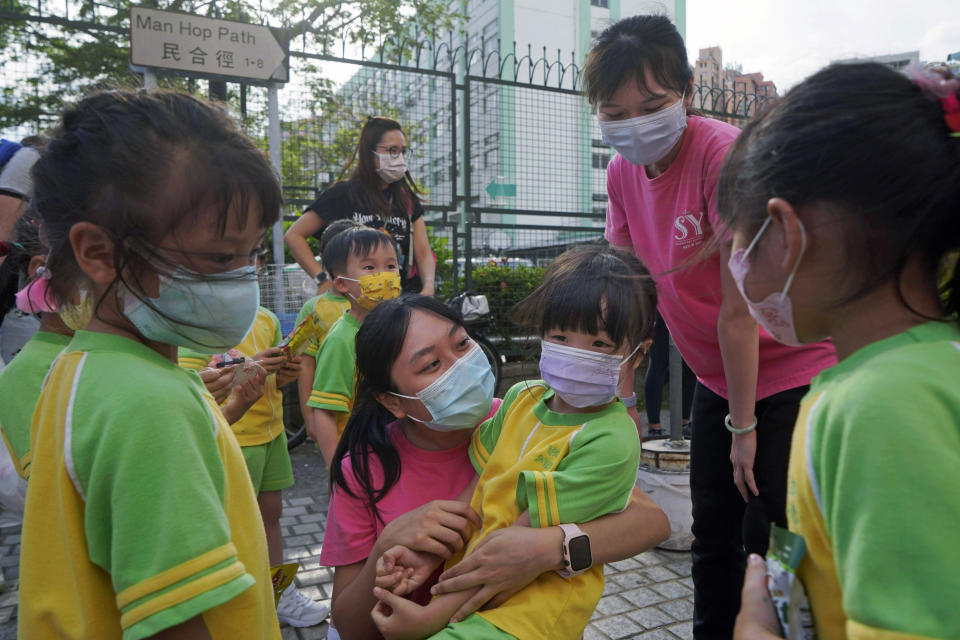 Daughter, center, of Mike Hui farewells to her classmates at a kindergarten in Hong Kong on May 20, 2021. Until early April, Hui was a photojournalist for the Apple Daily, a pro-democracy newspaper that shut down following the arrest of five top editors and executives and the freezing of its assets under a national security law that China's ruling Communist Party imposed on Hong Kong as part of the crackdown. (AP Photo/Kin Cheung)