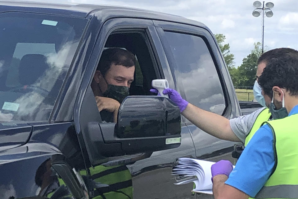 Driver Ryan Newman gets his temperature taken as he arrives at Darlington Raceway before the Real Heroes 400 NASCAR Cup Series auto race Sunday, May 17, 2020, in Darlington, S.C. NASCAR, which has been idle for 10 weeks because of the coronavirus pandemic, makes its return at the track Sunday. (AP Photo/Jenna Fryer)