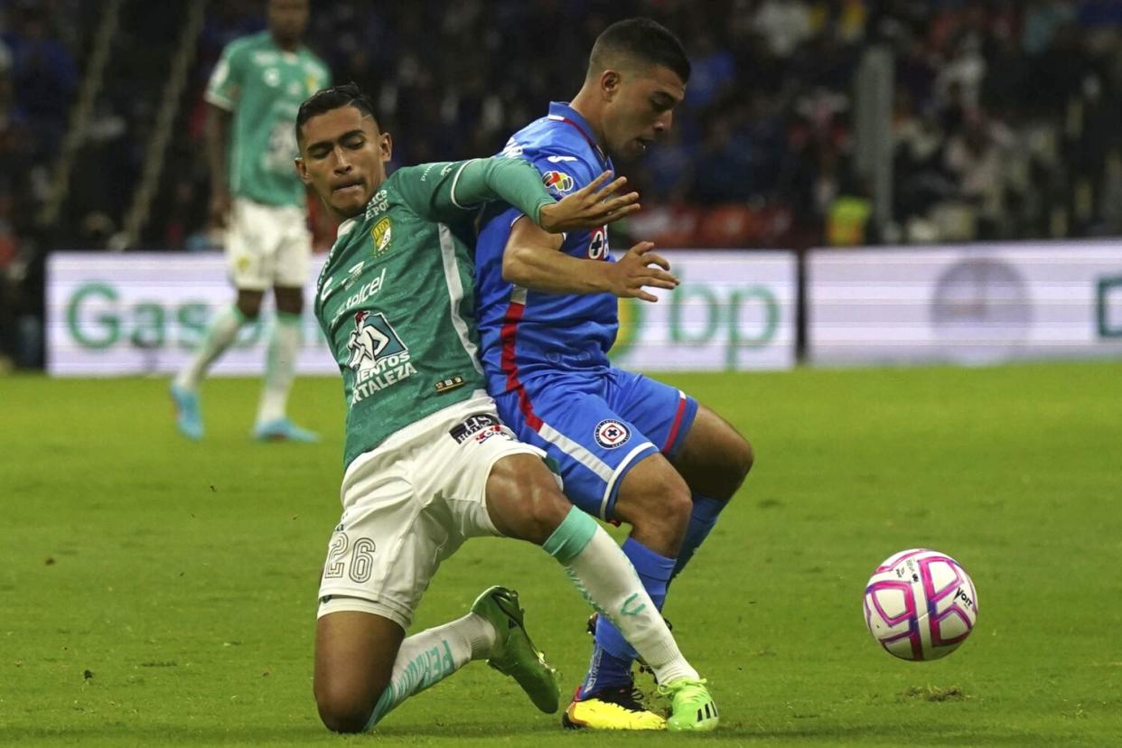 Léon's Fidel Ambríz and Cruz Azul's Erik Lira battle for the ball during a Liga MX match in Mexico City.