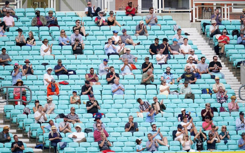 Spectators observe social distancing in the stands during the friendly match at the Kia Oval, London. - PA