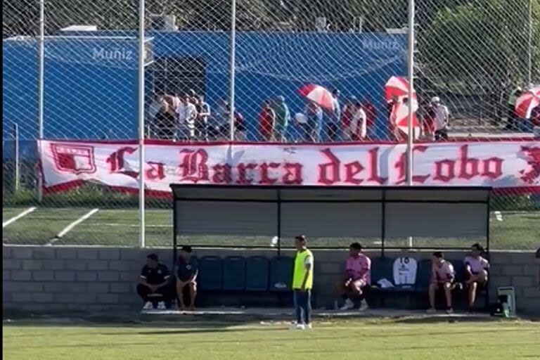 Los hinchas de Juventud Unida, detrás de uno de los bancos de suplentes y de las canchas de fútbol 5, en un andén de la estación Muñiz.