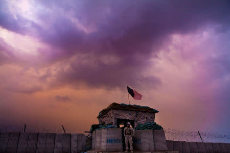 FILE PHOTO: A U.S. Marine from the First Battalion Eighth Marines Alpha Company looks out as an evening storm gathers above an outpost near Kunjak in southern Afghanistan's Helmand province, February 22, 2011. Picture taken February 22, 2011. REUTERS/Finbarr O'Reilly