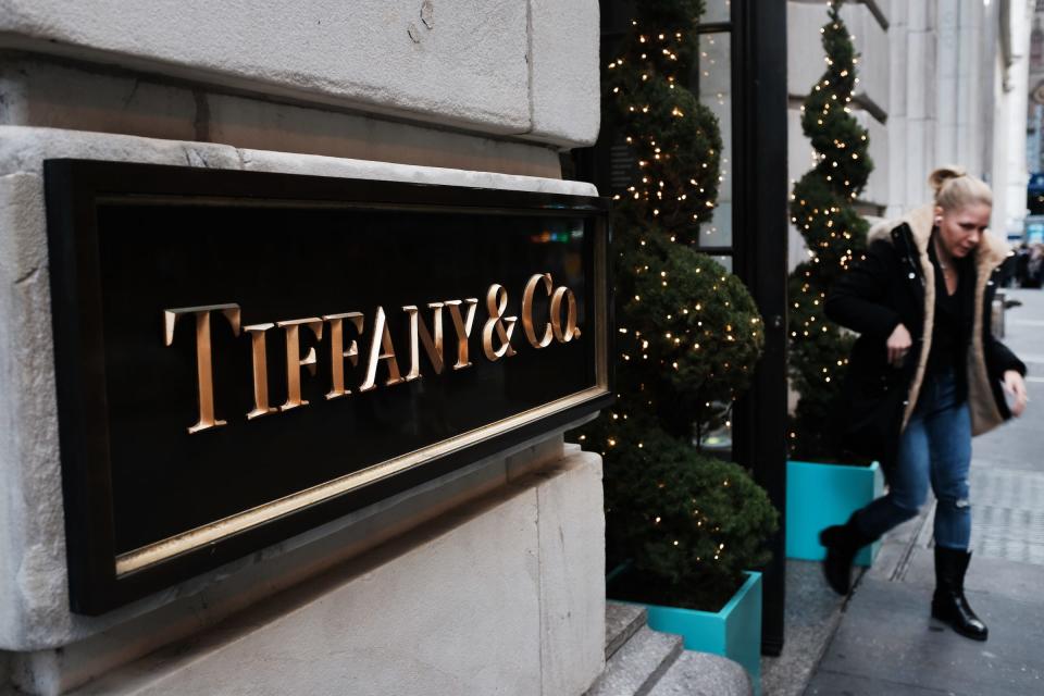 a woman walks out of a tiffany and co store