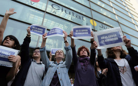 People shout slogans while holding signs during a protest outside the City of Justice, after a Spanish court on Thursday sentenced five men accused of the group rape of an 18-year-old woman at the 2016 San Fermin bull-running festival each to nine years in prison for the lesser charge of sexual abuse, in Valencia, Spain April 27, 2018. The signs read: "It is not abuse, it is rape". REUTERS/Heino Kalis?