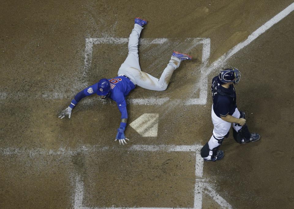 Chicago Cubs' Javier Baez scores past Milwaukee Brewers catcher Erik Kratz during the fourth inning of a baseball game Wednesday, Sept. 5, 2018, in Milwaukee. Baez scored on a ball hit by Anthony Rizzo. (AP Photo/Morry Gash)