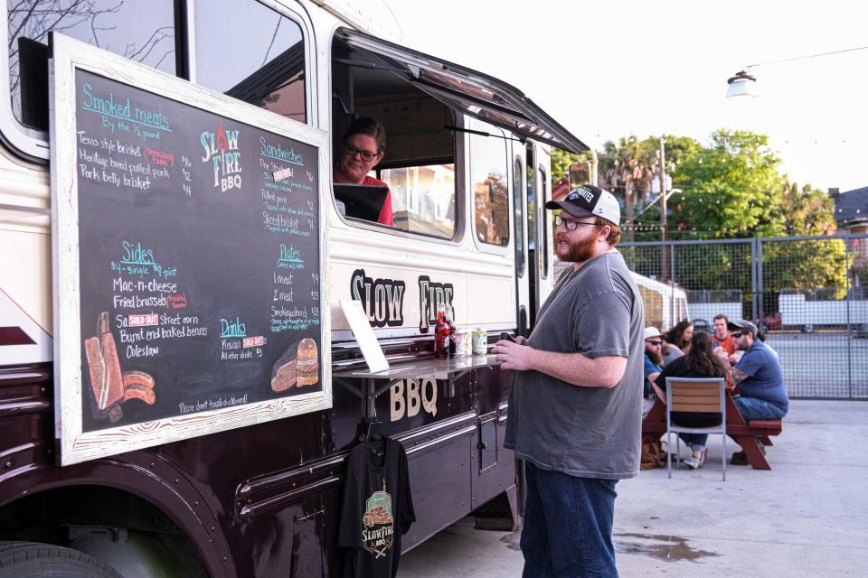 A customer at Starland Yard orders food from the Slow Fire BBQ food truck on Tuesday, April 4, 2023.