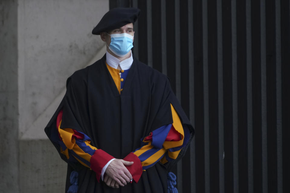 A Swiss Guard stands at the Vatican, Monday, Oct. 12, 2020. On Monday, Oct. 12, 2020, the Vatican said in a statement that four Swiss Guards have tested positive for the coronavirus, as the surge in infections in surrounding Italy enters the Vatican walls. (AP Photo/Andrew Medichini)