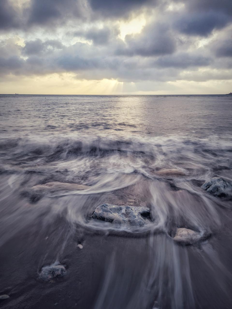 Sunrise beach with long exposure effect blurring the ocean water movement