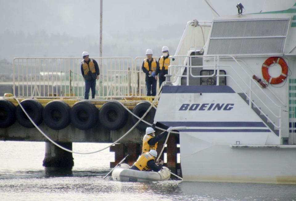 Coast guard crew investigate the damage of a ferry which collided at a port in Sado city, Niigata prefecture, Sunday, March 10, 2019. A ferry collided with what apparently was a marine animal off a Japanese island on Saturday, injuring more than 80 people, local media reported. The accident happened just after noon off Sado Island, Kyodo News agency reported, citing Japan's coast guard. (Kyodo News via AP)