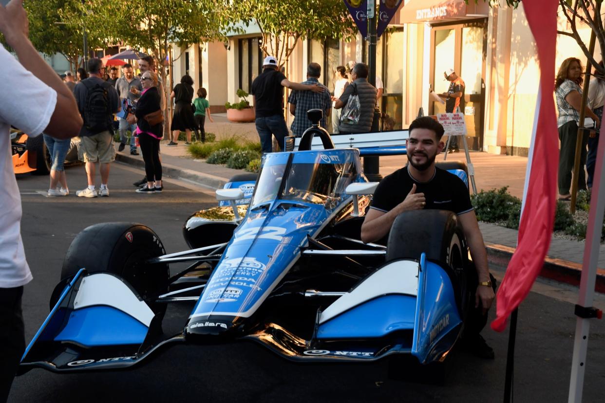 Eventgoers pose with race cars during Street Fest in Salinas on Sept. 7.