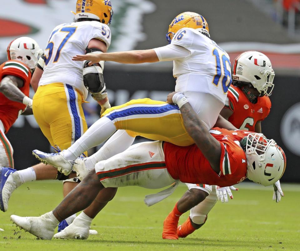 Miami defensive tackle Nesta Jade Silvera (1) tackles Pittsburgh quarterback Joey Yellen (16) in the second quarter of an NCAA college football game at Hard Rock Stadium in Miami Gardens, Fla., Saturday, Oct. 17, 2020. (Al Diaz/Miami Herald via AP)