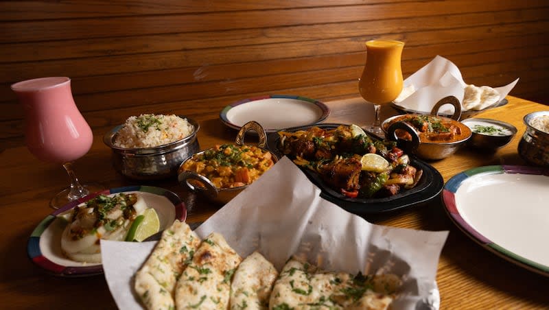 An arrangement of dishes, including naan, rice, lassis, raita, different curries and a tandoori dish, are set out for a photo at Mumbai House in Salt Lake City on Tuesday, May 14, 2024.