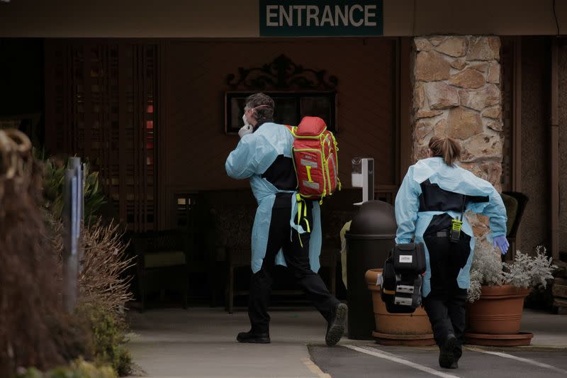 Medics prepare to transfer a patient on a stretcher to an ambulance at the Life Care Center of Kirkland, the long-term care facility linked to the two of three confirmed coronavirus cases in the state, in Kirkland