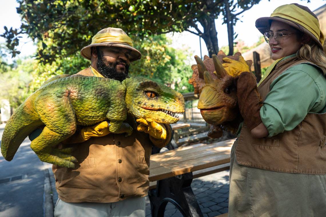 Dan Bluitt, left, and Scarlett Cardona, right, put on a puppet demonstration during an inside look of Six Flags Over Texas’ revamped ride, Dino Off Road Adventure, on Friday, June 21, 2024, in Arlington. The workers named the puppets, Tyler T-rex and Sarah Triceratops.