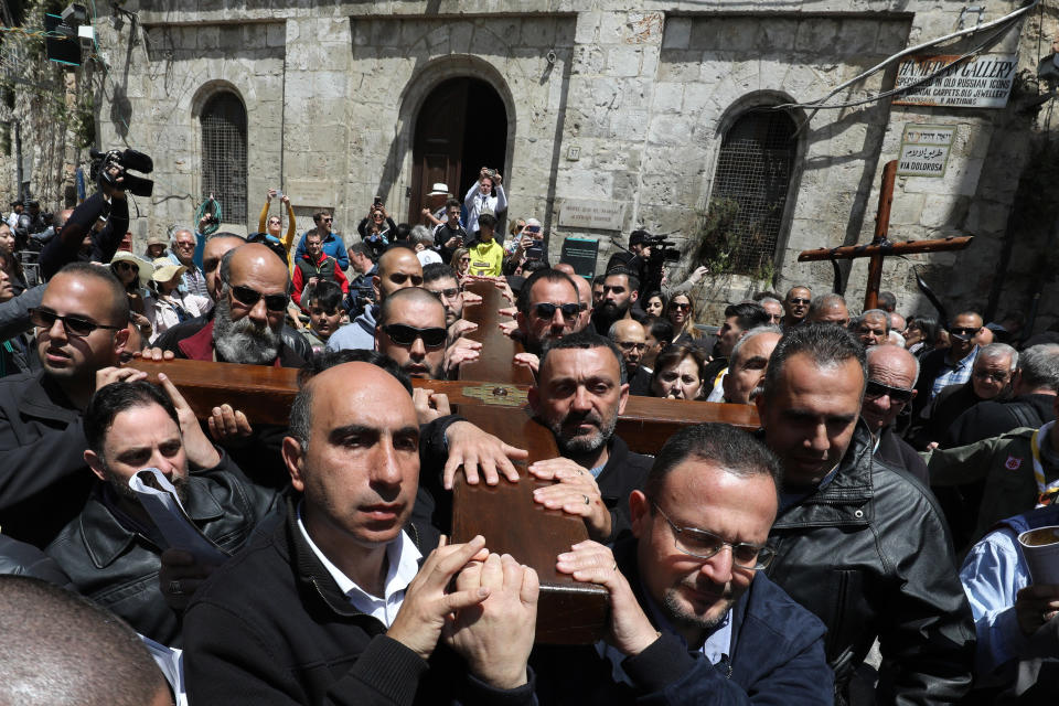 Members of a local Catholic Palestinian parish carry a wooden cross along the Via Dolorosa (Way of Suffering) in Jerusalem's Old City on Good Friday. (GALI TIBBON via Getty Images)